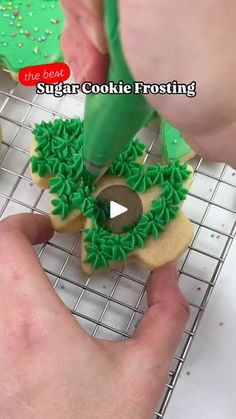 someone is decorating some cookies with green icing