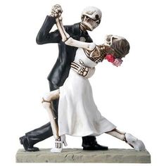 a figurine of a skeleton dancing with a woman in a white dress and black suit