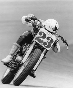 a man riding on the back of a motorcycle down a race track with number 33 written on it