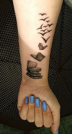 a woman's arm with books flying out of it and birds in the sky