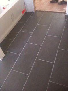 a bathroom with tile flooring next to a bath tub