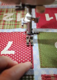 someone is using a sewing machine to sew the letters on quilts that are red, green and white