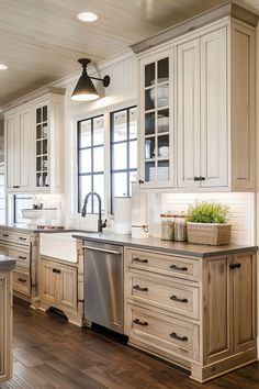 a large kitchen with white cabinets and wood flooring, along with stainless steel appliances