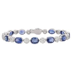 Blue Sapphire and Diamond bracelet in 18K Gold. It has a perfect oval cut gemstone to make you stand out on any occasion or an event. A tennis bracelet is an essential piece of jewelry when it comes to your wedding day. The sleek and elegant style complements the attire beautifully, whether it's the bride wearing it herself, or as a gift to her bridesmaids to wear on the D’day. Bracelets are worn to enhance the look. Women love to look good. It is common to see a woman rocking a lovely gold brac Classic Oval Gemstone Tennis Bracelet, Formal Oval Gemstone Tennis Bracelet, Luxury Blue Oval Diamond Bracelet, Luxury Oval Sapphire Tennis Bracelet, Classic Blue Diamond Bracelet For Wedding, Blue Oval Tennis Bracelet For Formal Occasions, Classic Blue Diamond Wedding Bracelet, Formal Blue Oval Diamond Bracelet, Oval Sapphire Tennis Bracelet With 17 Jewels