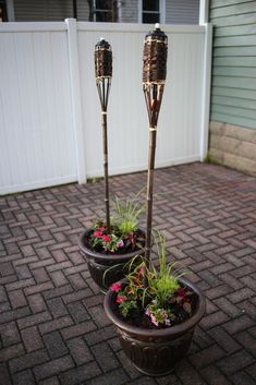 two planters with plants in them sitting on the ground