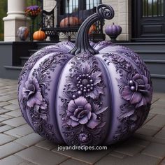 a large purple pumpkin sitting on top of a sidewalk