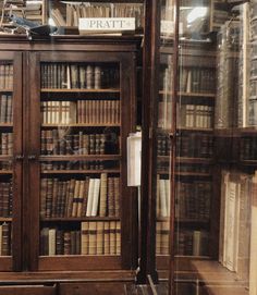 an old bookcase with many books in it and some signs on the glass doors