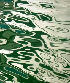 the water is very green and has some interesting patterns on it