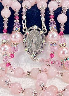 "Magnificent rosary made with 8mm genuine Madagascar Rose Quartz gemstones, Austrian crystal pearls, Preciosa crystals and silver plated embellishments. This rosary is very dressy and formal, yet perfect for every Sacramental occasion, First Communion, Wedding, Confirmation, or that special gift that says, \"I'm thinking of you\". If you're wanting Swarovski pearls, I think you'll find the quality of these Rosaline pearls to match them in weight, color, and bright luster finish! I use these inte Cheap Elegant Rosary As A Gift, Handmade Rosary Bracelet With Round Beads For Wedding, Elegant Pink Wedding Rosary Bracelet, Elegant Pink Rosary Bracelet For Wedding, Spiritual Wedding Jewelry With 8mm Beads, Spiritual 8mm Beads Jewelry For Wedding, Spiritual Beaded Rosary Bracelet For Wedding, Pink 8mm Beads Jewelry For Wedding, Kailey Core