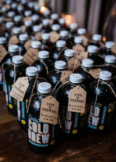 several bottles of cold brew sitting on top of a wooden table with tags attached to them