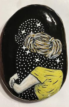 a hand painted rock with a woman's face and stars in the night sky