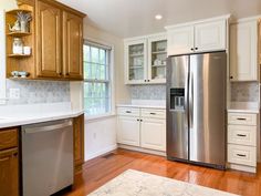 a kitchen with white cabinets and stainless steel appliances