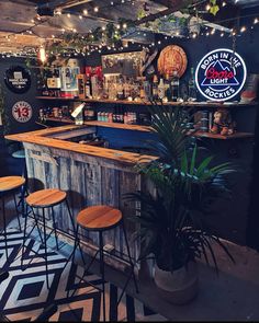 a bar with several stools in front of it and lights hanging from the ceiling