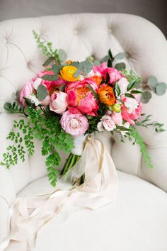 a bouquet of flowers sitting on top of a white chair