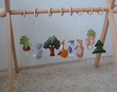 a wooden swing with several stuffed animals hanging from it's sides and on the strings