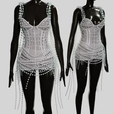 two mannequins with chains and beads on them, one is wearing a white dress