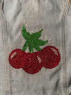 a jean jacket with sequins and cherries on it