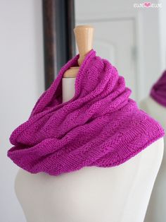 a white mannequin with a purple knitted scarf on it's neck