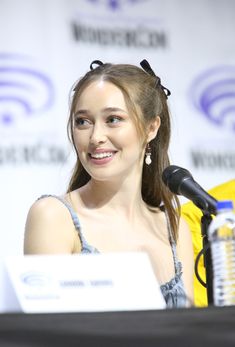 a woman sitting in front of a microphone