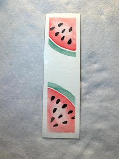 a watermelon bookmark with black dots on it