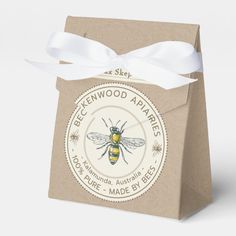 a brown paper bag with a white ribbon around it and a bee logo on the front