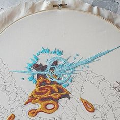 a close up of a embroidery on a piece of cloth with an image of a dragon