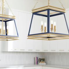 two blue and gold chandeliers hanging in a kitchen