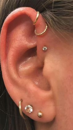 a woman wearing three different ear piercings on her left ear and the other one is in