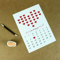 a calendar with hearts drawn on it next to a marker