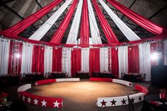 an empty circus ring with red and white curtains