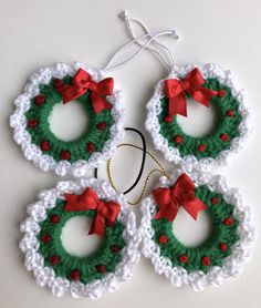 three crocheted christmas wreath ornaments with red bows