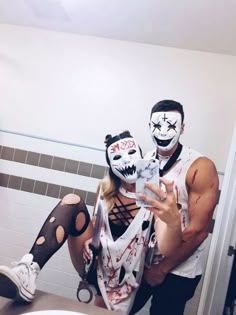 a man and woman dressed up as zombies in a bathroom with their faces painted white