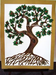 a paper cut christmas tree with green leaves and red berries on the top is shown