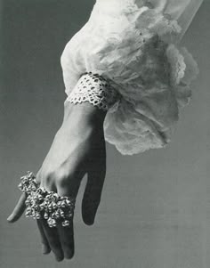 a black and white photo of a woman's hand with bracelets