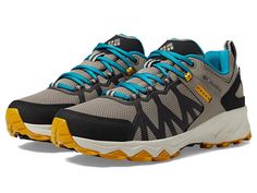 a pair of grey and blue shoes with yellow laces on the outstretches