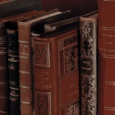 an assortment of books are lined up on the shelf in front of each other,