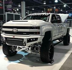 a white truck is on display at an auto show