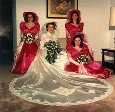 three women in dresses and hats are posing for a photo with one another on the floor