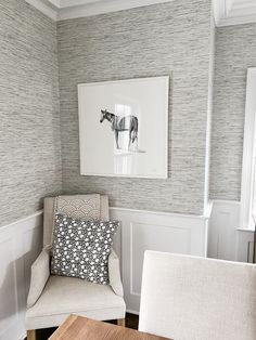 a chair and table in a room with white wains on the wall behind it