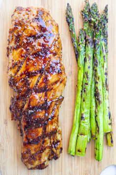 grilled chicken and asparagus on a cutting board