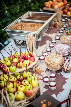 a table topped with lots of apples and desserts next to other foods on plates