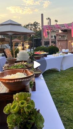 there is a table set up with food on it and flowers in the vases