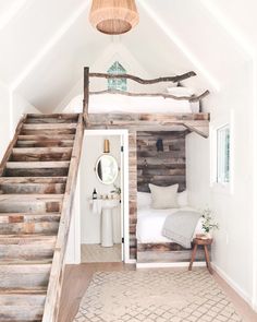 a bedroom with wooden stairs leading up to the top floor and bed in the loft