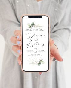 a person holding up a phone with the wedding announcement on it