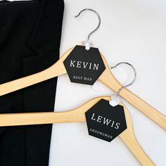 two wooden clothes hangers with name tags on them