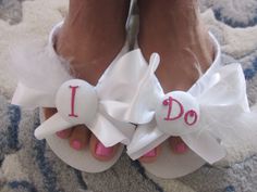 a woman's feet wearing white sandals with bows and i do decorations on them