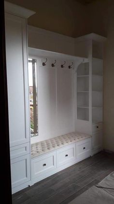 an empty room with built - in shelves, drawers and a mattress on the floor