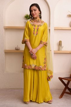 Mustard yellow kurta with thread, floral embroidery on placket and sleeve hem. Paired with sharara and dupatta.
Component: 3
Pattern: Embroidery
Type Of Work: Thread, floral
Neckline: Round
Sleeve Type: Three quarter
Fabric: Chanderi, organza
Color: Yellow
Other Details: 
Scallop bordered sheer dupatta
Occasion: Mehendi and Haldi - Aza Fashions Sheer Dupatta, Yellow Kurta, Kurta Sharara Set, Kurta Sharara, Chanderi Kurta, Sharara Set, Set For Women, Embroidery Thread, Mustard Yellow