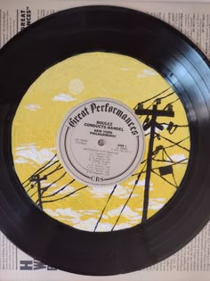 a record with an image of power lines on the side and yellow sky in the background