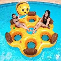 two women sitting on inflatable rafts floating in a pool with a smiley face balloon